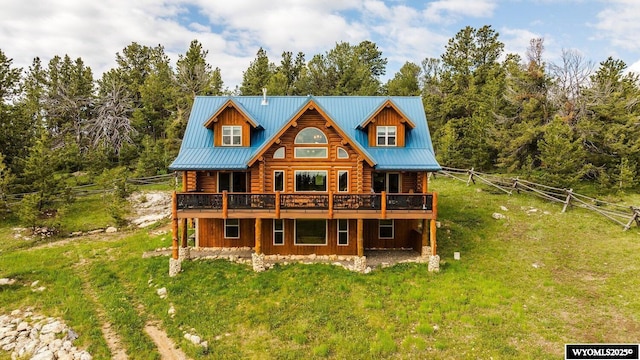 18 High Meadows Rd, Buffalo, WY 82834 - rear view of property featuring metal roof, a deck, log siding, fence, and a yard