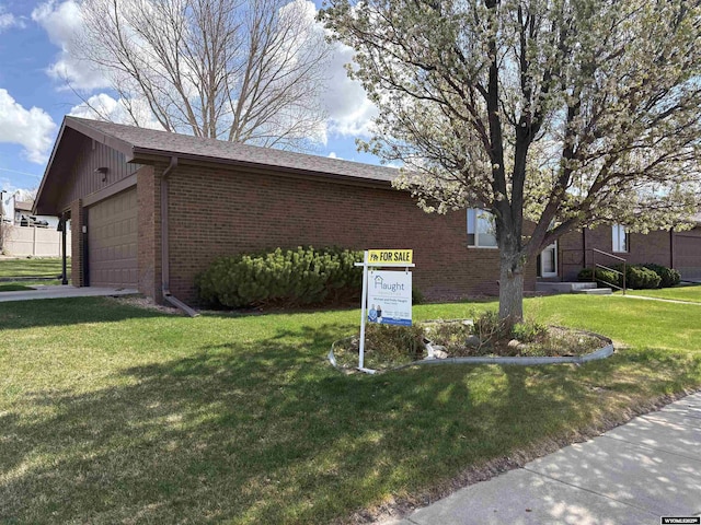 2327 Crestview Dr, Torrington, WY 82240 - view of home's exterior with brick siding and a lawn