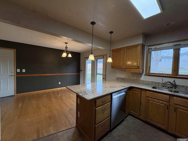 2327 Crestview Dr, Torrington, WY 82240 - kitchen featuring stainless steel dishwasher, a peninsula, a healthy amount of sunlight, a sink, and hanging light fixtures