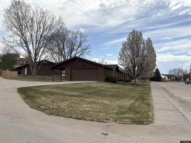 2327 Crestview Dr, Torrington, WY 82240 - view of home's exterior with a garage, a lawn, and brick siding