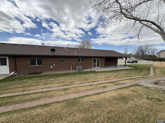 2327 Crestview Dr, Torrington, WY 82240 - rear view of property with fence, central AC, a patio, brick siding, and a yard