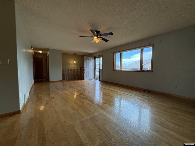 2327 Crestview Dr, Torrington, WY 82240 - unfurnished living room with a textured ceiling, ceiling fan, baseboards, and light wood finished floors