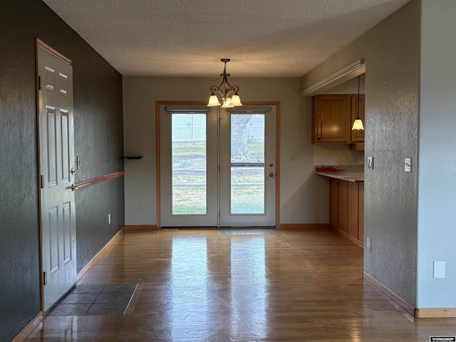 2327 Crestview Dr, Torrington, WY 82240 - unfurnished dining area featuring baseboards, a notable chandelier, and light wood finished floors