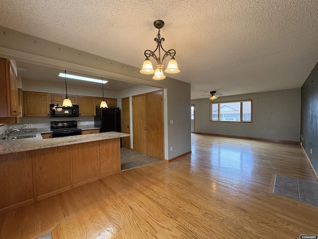 2327 Crestview Dr, Torrington, WY 82240 - kitchen featuring a peninsula, a sink, black appliances, and light wood-type flooring