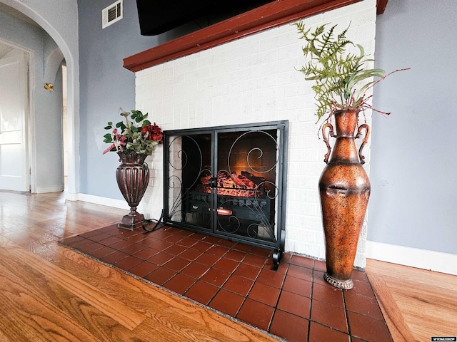 interior details featuring arched walkways, baseboards, visible vents, and a fireplace