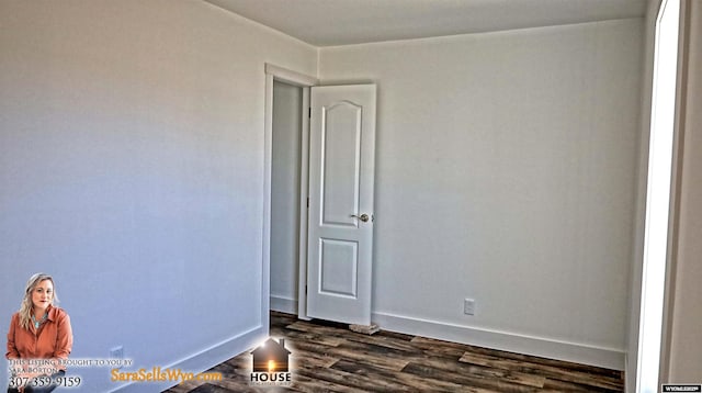 spare room with baseboards and dark wood-type flooring