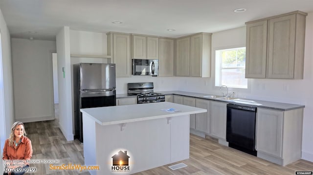 kitchen featuring freestanding refrigerator, black dishwasher, a center island, a sink, and gas stove
