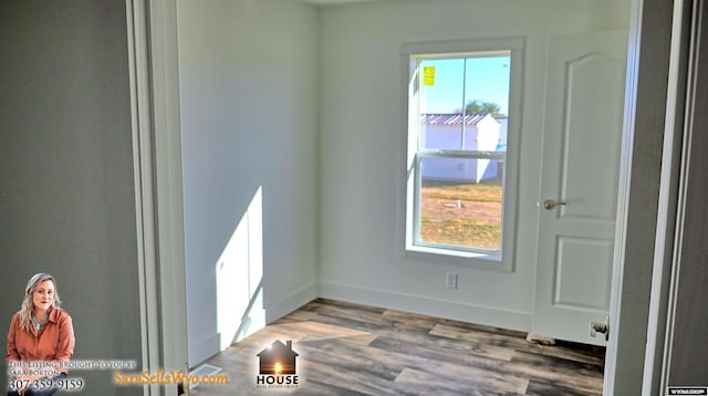 spare room with baseboards and wood finished floors