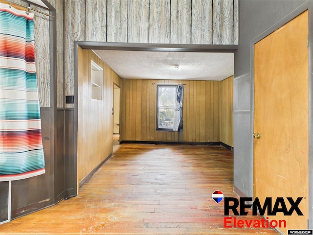 602 S 6th St, Basin, WY 82410 - spare room with wood-type flooring, wood walls, baseboards, and a textured ceiling