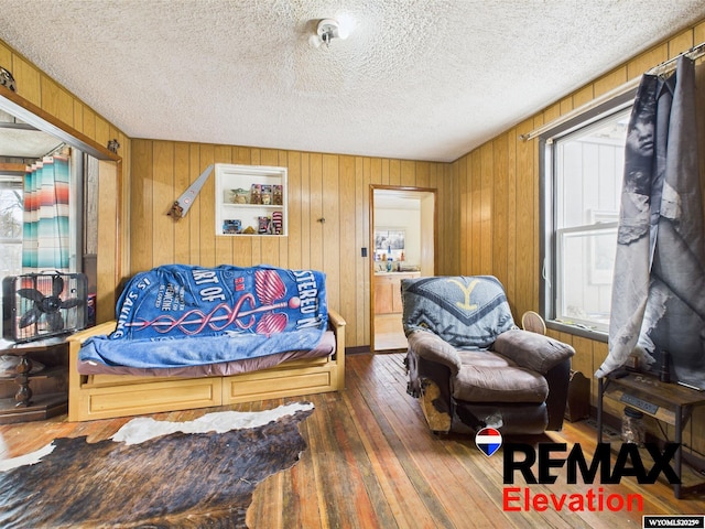 602 S 6th St, Basin, WY 82410 - living area featuring wood-type flooring, a textured ceiling, and wood walls