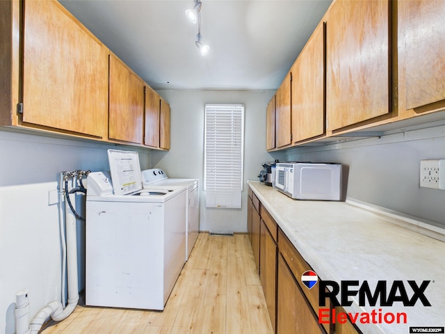 602 S 6th St, Basin, WY 82410 - washroom featuring rail lighting, light wood finished floors, cabinet space, and washing machine and dryer