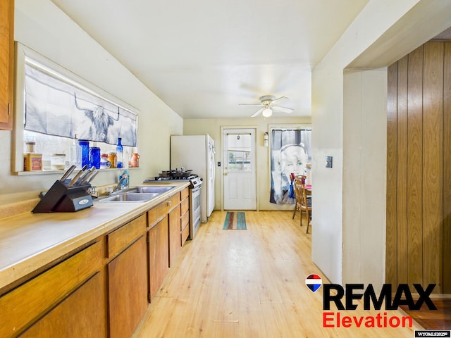 602 S 6th St, Basin, WY 82410 - kitchen featuring brown cabinetry, gas range, light countertops, a sink, and light wood finished floors