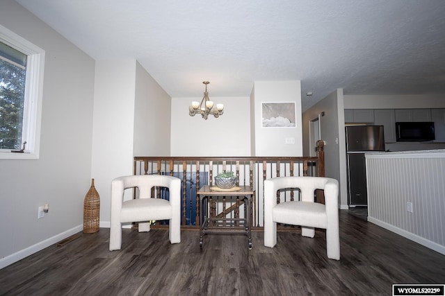living area featuring baseboards, dark wood-style flooring, and a chandelier