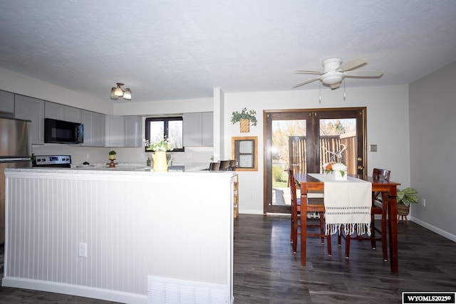 kitchen with baseboards, a textured ceiling, gray cabinets, and black microwave