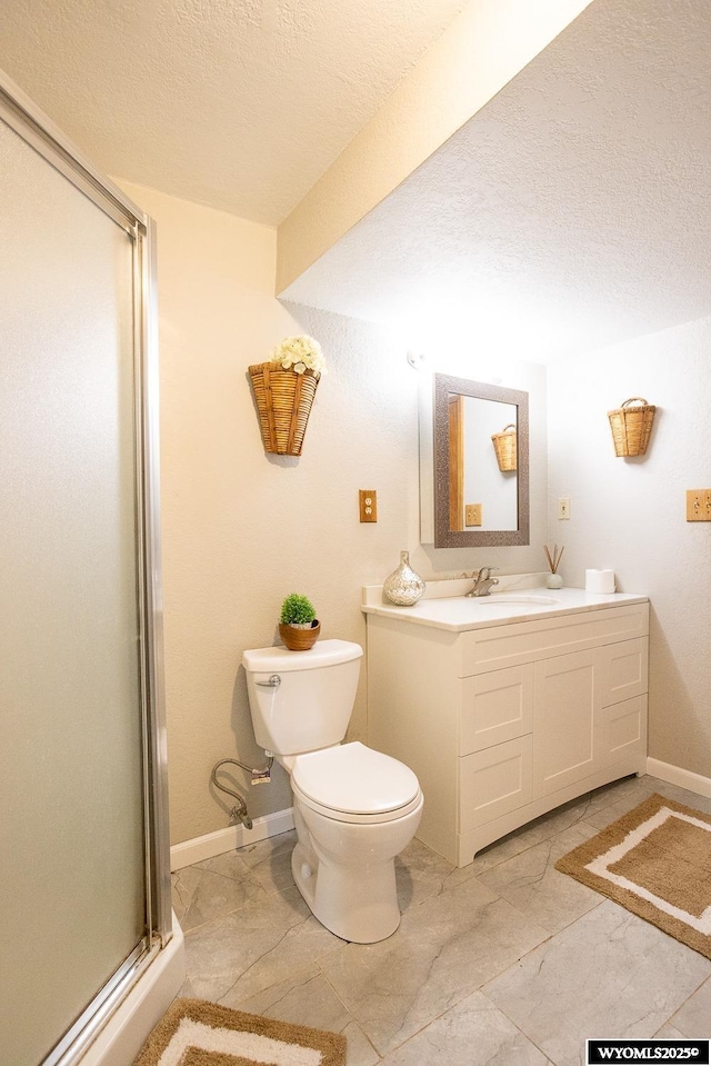 full bath with vanity, toilet, baseboards, a textured ceiling, and a stall shower