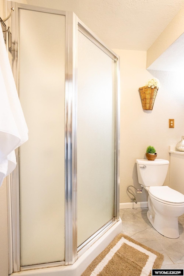 full bathroom featuring tile patterned flooring, a stall shower, and toilet