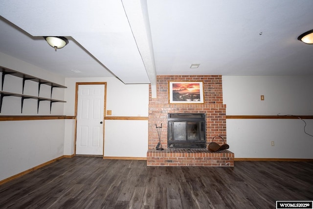 unfurnished living room with baseboards, wood finished floors, and a fireplace