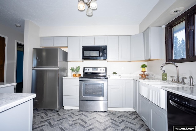 kitchen featuring a sink, light stone countertops, and black appliances