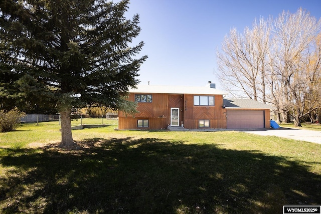 split foyer home with fence, a chimney, concrete driveway, and a front yard