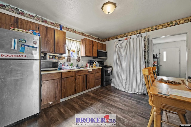 1105 N Elma, Casper, WY 82601 - kitchen featuring light countertops, stainless steel appliances, a textured ceiling, and dark wood-style floors