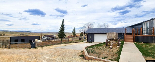 5421 S Okeepa, Casper, WY 82604 - view of front of house with board and batten siding, driveway, a garage, fence, and a mountain view