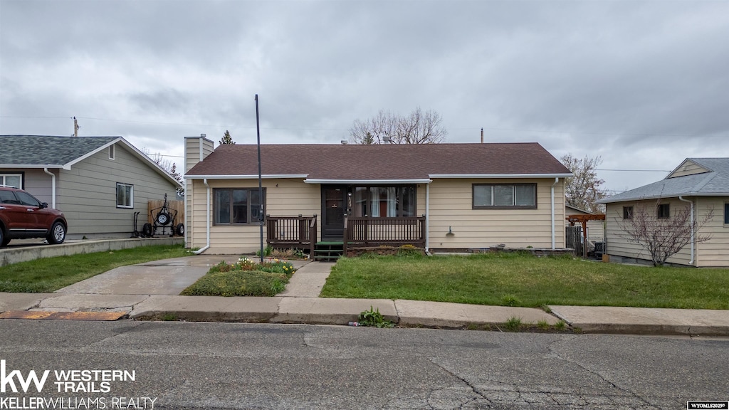 1544 S Wilson St, Casper, WY 82601 - bungalow with a front lawn, roof with shingles, a chimney, and covered porch