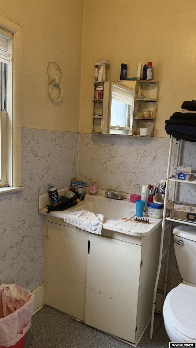 half bath featuring vanity and toilet