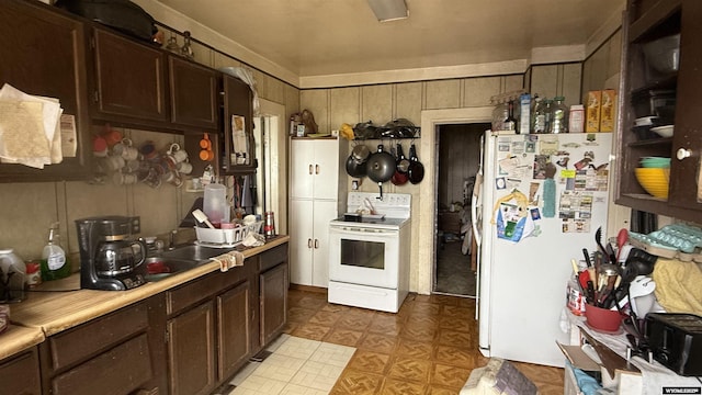 kitchen with white appliances, dark brown cabinets, and light countertops