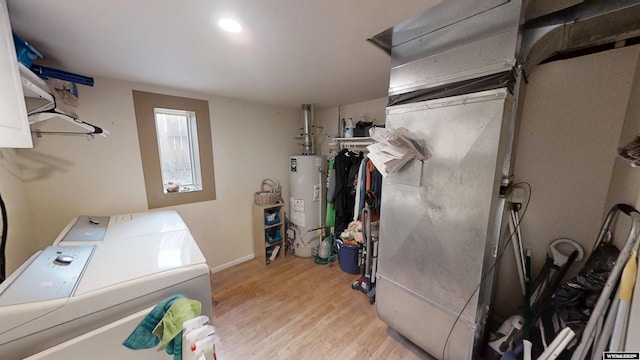 laundry area featuring laundry area, washing machine and clothes dryer, wood finished floors, baseboards, and water heater
