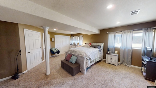 bedroom featuring baseboards, light carpet, ornate columns, and visible vents