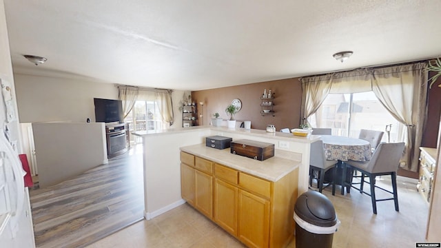kitchen featuring light countertops, a center island, and light brown cabinetry