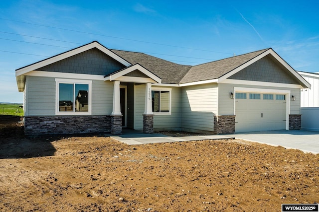 1275 Oxbow Dr, Sheridan, WY 82801 - craftsman inspired home featuring roof with shingles, concrete driveway, a garage, and stone siding