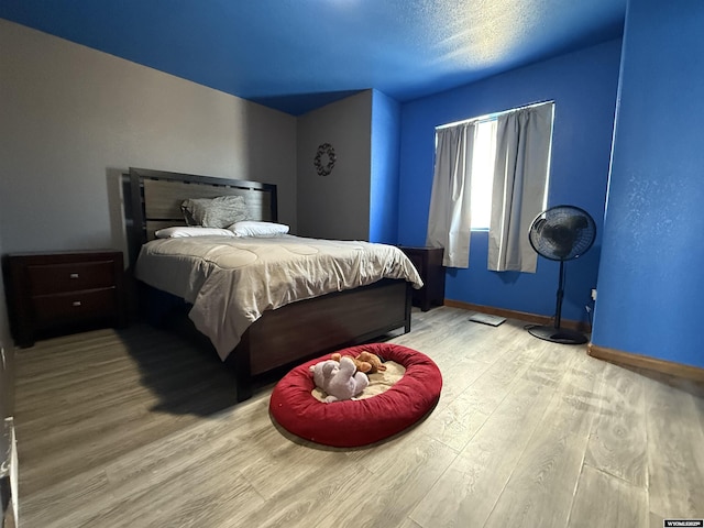 bedroom featuring baseboards and wood finished floors
