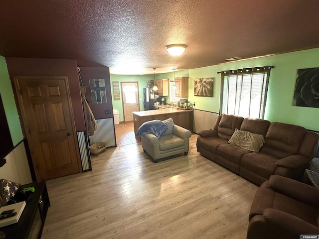 living area with light wood finished floors and a textured ceiling