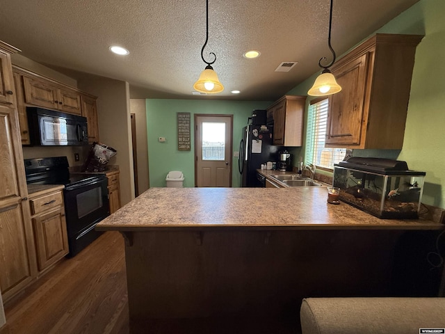 kitchen featuring black appliances, a sink, visible vents, and a textured ceiling