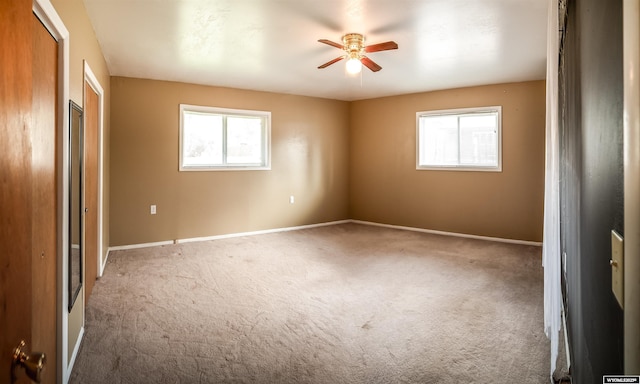 spare room featuring carpet flooring, ceiling fan, and baseboards
