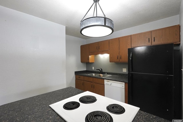 kitchen with freestanding refrigerator, white dishwasher, range, a sink, and dark countertops
