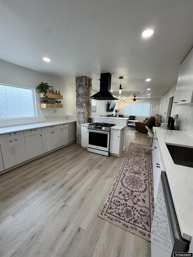 822 W St, Rock Springs, WY 82901 - kitchen with island range hood, gas range, open floor plan, light countertops, and light wood-style floors