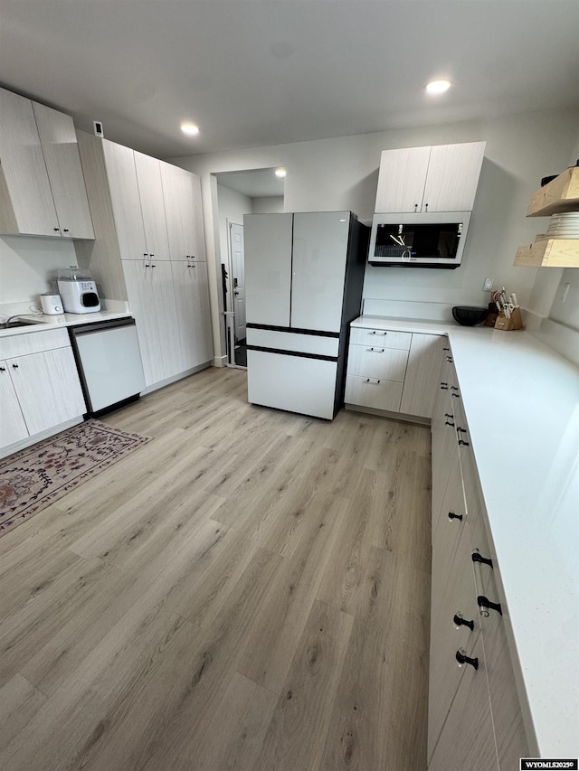 822 W St, Rock Springs, WY 82901 - kitchen featuring freestanding refrigerator, dishwasher, light wood-style flooring, light countertops, and recessed lighting