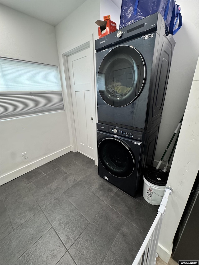 822 W St, Rock Springs, WY 82901 - washroom with stacked washer / dryer, dark tile patterned floors, and baseboards