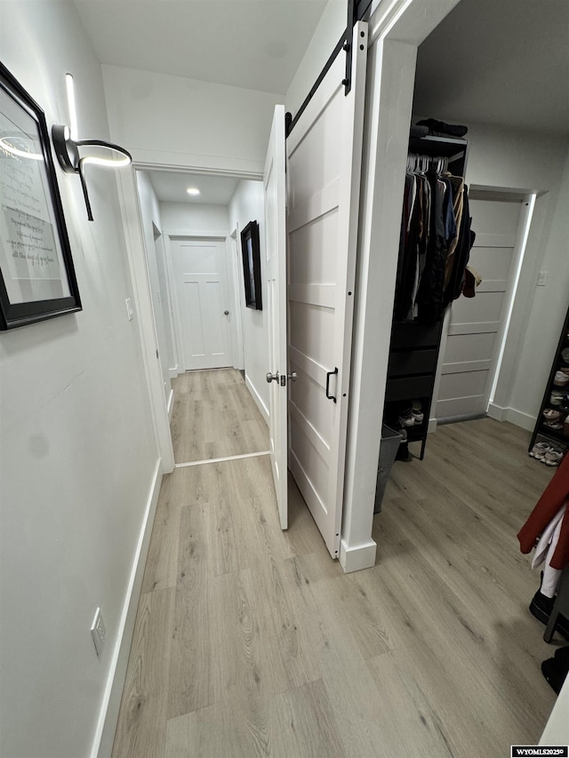 822 W St, Rock Springs, WY 82901 - hall featuring a barn door, light wood-style floors, baseboards, and recessed lighting