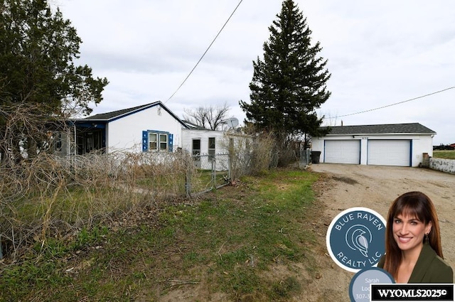 view of front of home featuring fence, a garage, and an outdoor structure