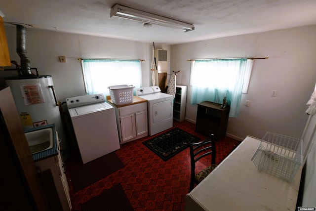 clothes washing area with cabinet space, washing machine and dryer, and gas water heater