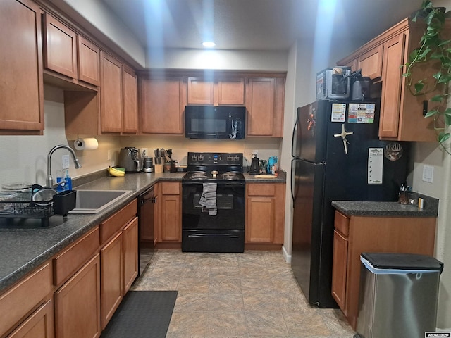 70B 27th St, Wheatland, WY 82201 - kitchen with dark countertops, brown cabinets, black appliances, and a sink