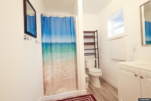 bathroom with toilet, a shower with curtain, wood finished floors, vanity, and baseboards