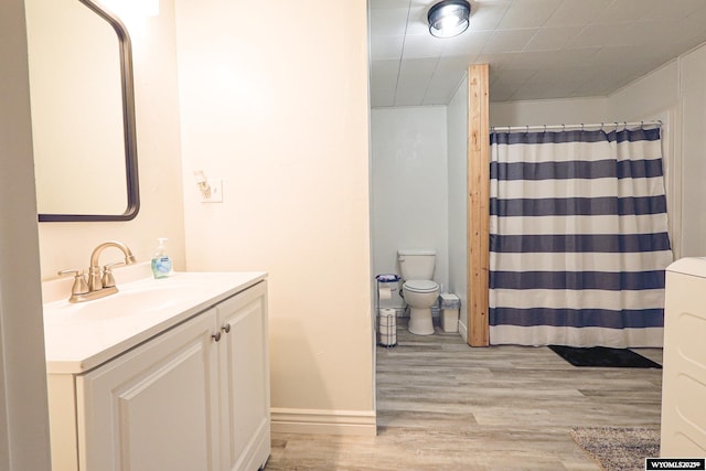 full bath with toilet, baseboards, a shower with shower curtain, vanity, and wood finished floors