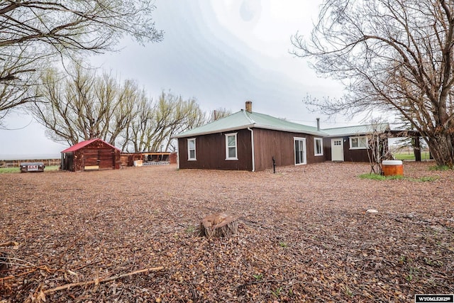 view of property exterior featuring metal roof and a chimney