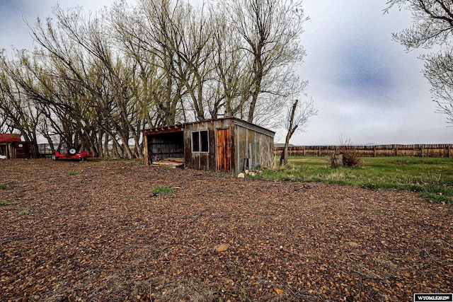 view of yard with an outbuilding, fence, and a pole building