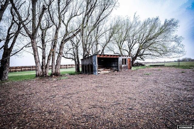 view of yard featuring an outbuilding, an outdoor structure, and fence