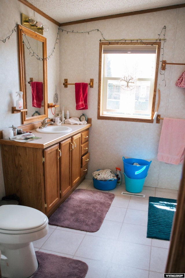 bathroom featuring toilet, tile patterned flooring, vanity, and a textured ceiling